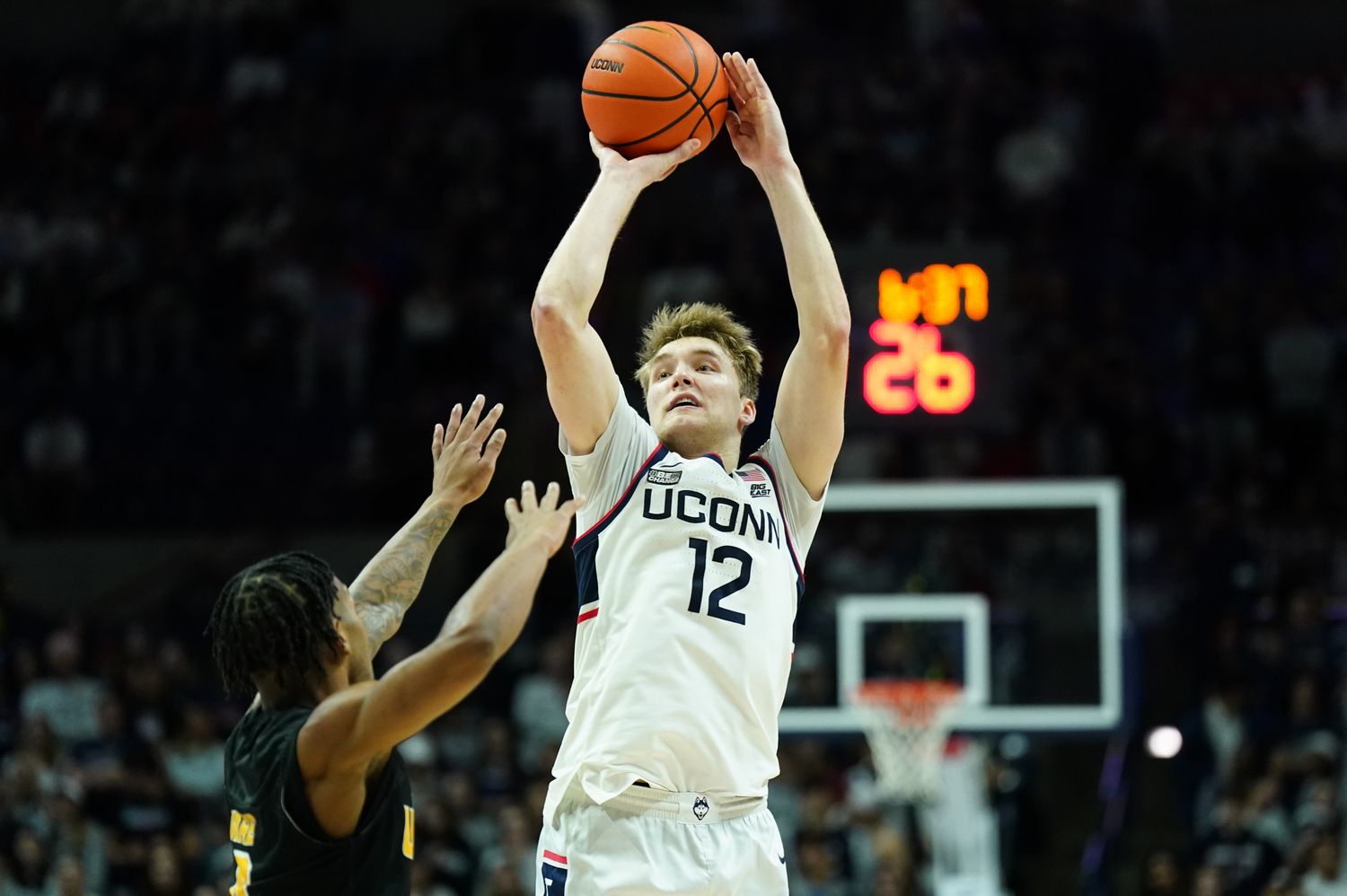 Dec 9, 2023; Storrs, Connecticut, USA; UConn Huskies guard Cam Spencer (12) makes the basket against Arkansas-Pine Bluff Golden Lions guard Kylen Milton (1) in the second half at Harry A. Gampel Pavilion. Mandatory Credit: David Butler II-USA TODAY Sports  